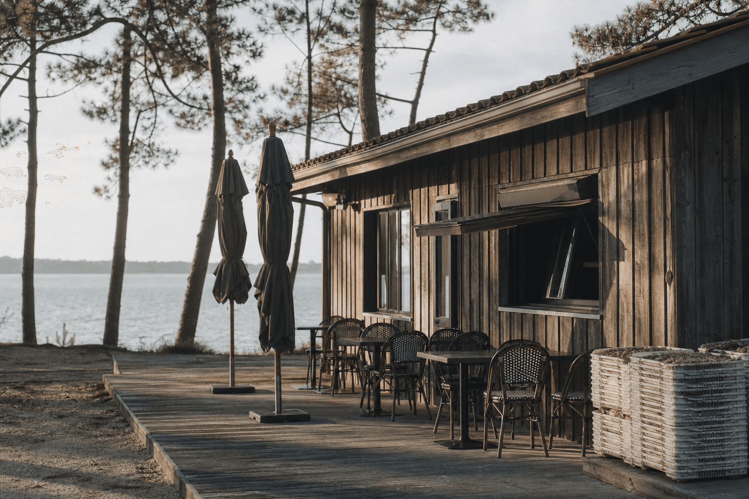 Terrasse en bois d’une cabane ostréicole au bord de l’eau, en fin d’après-midi
